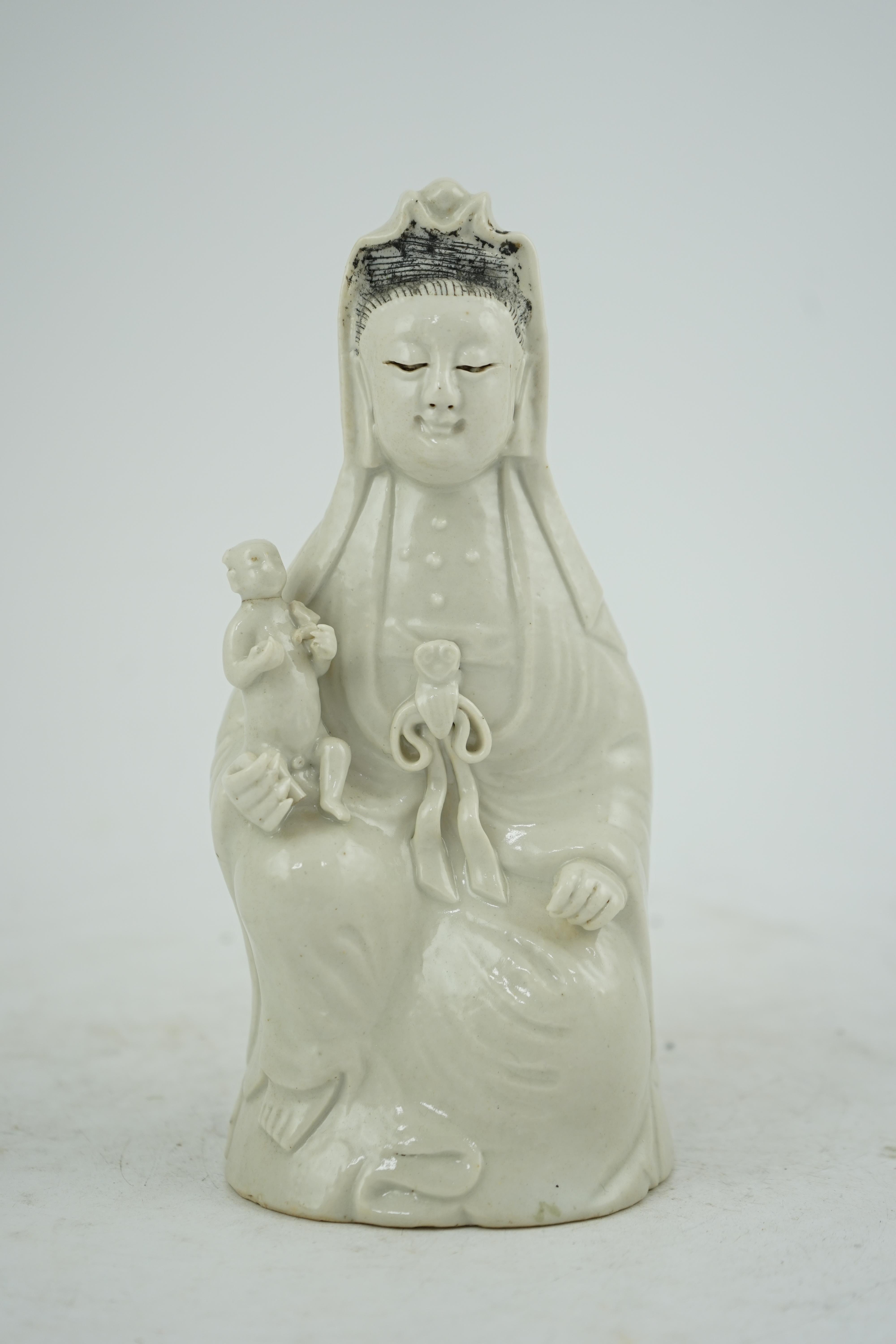 A Chinese white glazed group of Guanyin and child, 18th/19th century